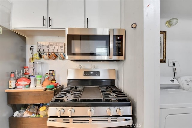 kitchen featuring white cabinetry, stainless steel appliances, and washer and dryer