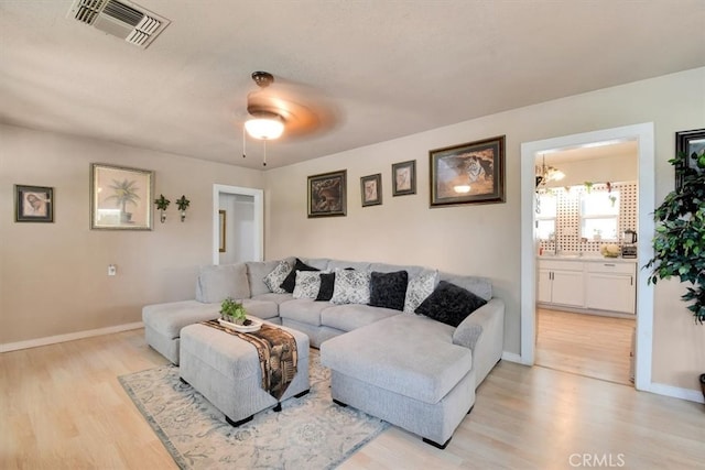 living room featuring light hardwood / wood-style flooring and ceiling fan