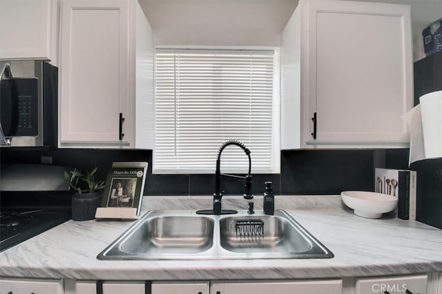 kitchen featuring white cabinetry and sink