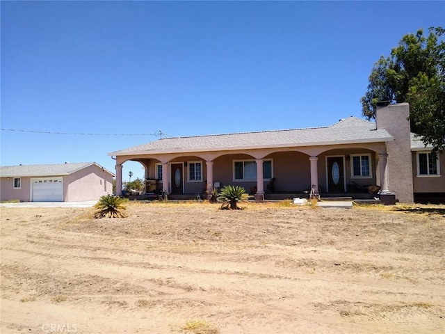 ranch-style house featuring covered porch and a garage