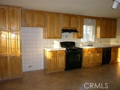 kitchen with black appliances, tile patterned floors, and sink