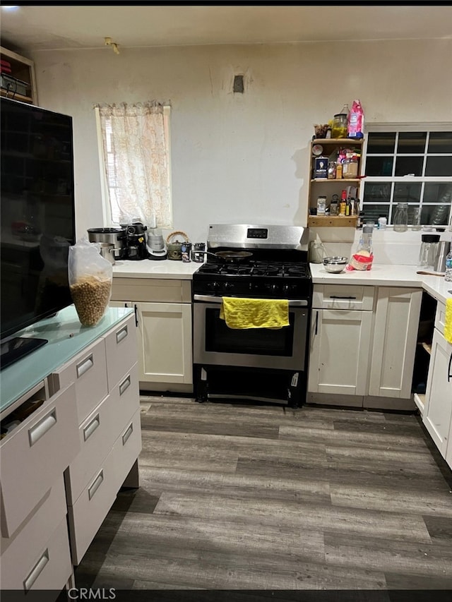 kitchen featuring gas stove, white cabinetry, and dark hardwood / wood-style flooring