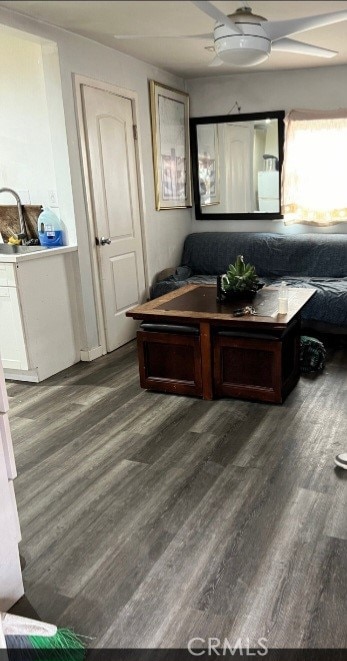 living room featuring ceiling fan and dark hardwood / wood-style flooring