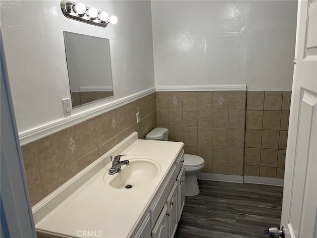 bathroom featuring tile walls, hardwood / wood-style floors, vanity, and toilet