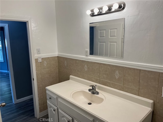 bathroom with wood-type flooring, vanity, and tile walls