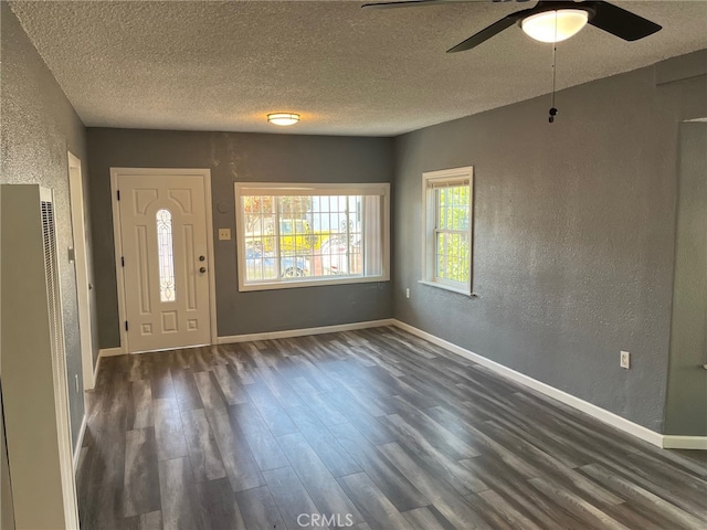 entrance foyer featuring ceiling fan, dark wood-type flooring, and a textured ceiling