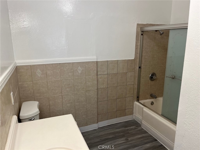 full bathroom with enclosed tub / shower combo, vanity, hardwood / wood-style flooring, tile walls, and toilet