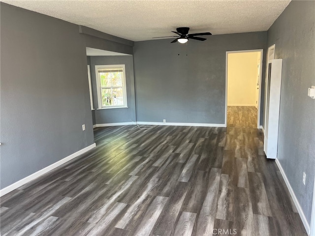 empty room featuring ceiling fan, dark hardwood / wood-style floors, and a textured ceiling