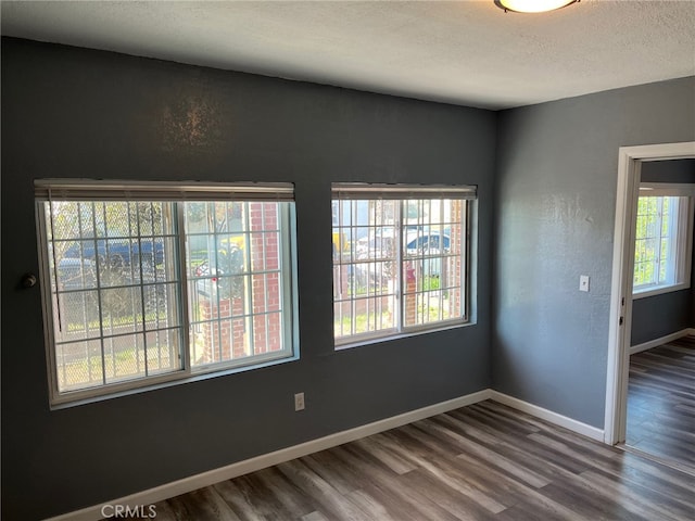 empty room with a textured ceiling and hardwood / wood-style floors