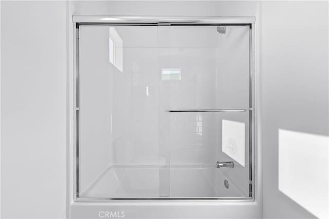 bathroom with bath / shower combo with glass door