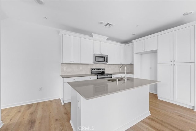 kitchen featuring white cabinetry, an island with sink, appliances with stainless steel finishes, and sink