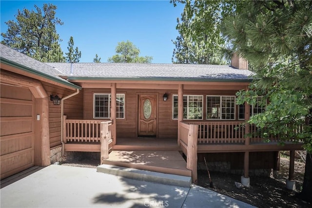 property entrance featuring covered porch and a garage