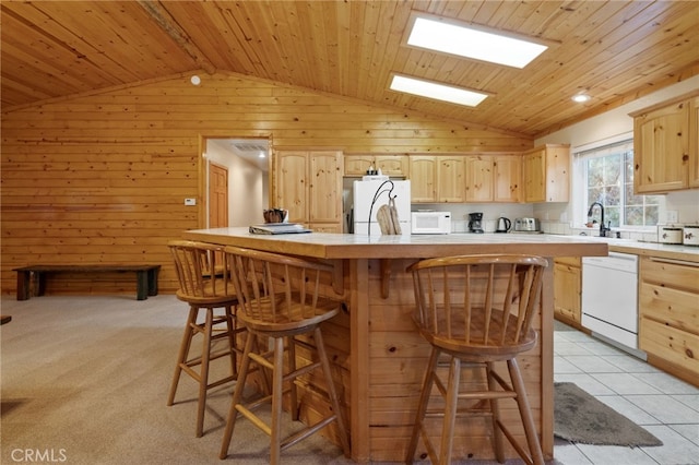 kitchen with white appliances, wooden walls, and light brown cabinetry