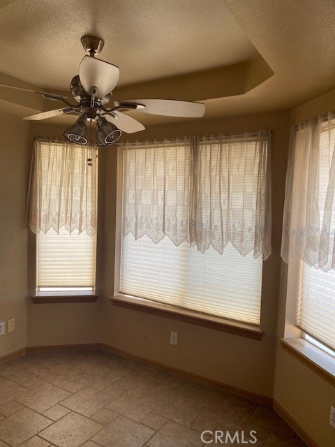 unfurnished room featuring ceiling fan and a textured ceiling