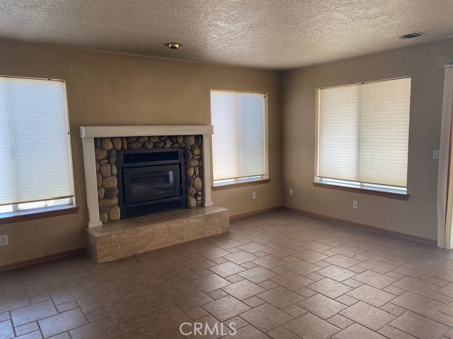 unfurnished living room with a textured ceiling and a fireplace