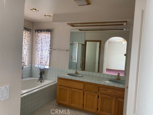 bathroom with shower with separate bathtub, vanity, and tile patterned floors