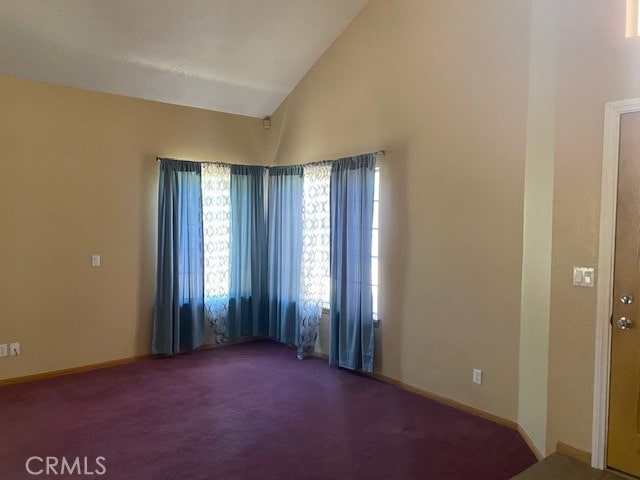 unfurnished room with high vaulted ceiling and carpet flooring