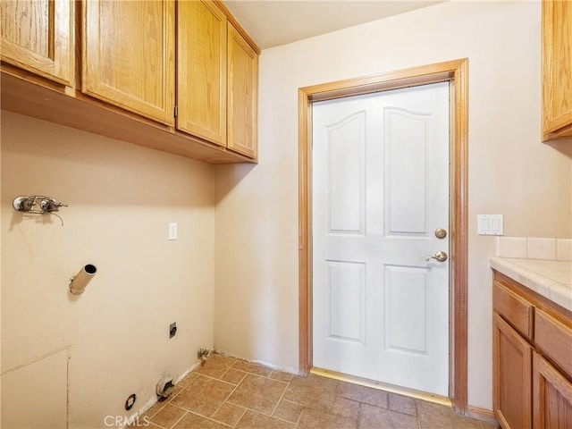 8187 Anaconda Ave, Oak Hills, CA 92344 - laundry room featuring electric dryer hookup, cabinet space, gas dryer hookup, and stone finish flooring