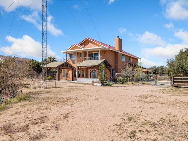 8187 Anaconda Ave, Oak Hills, CA 92344 - rear view of property with a gate, stucco siding, fence, and a chimney