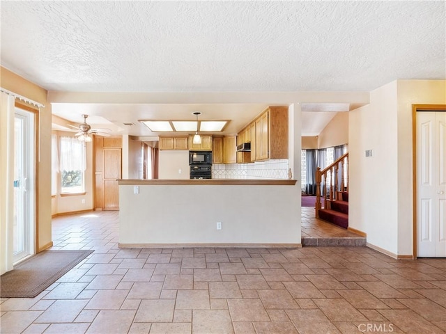 8187 Anaconda Ave, Oak Hills, CA 92344 - kitchen with decorative backsplash, a peninsula, baseboards, a ceiling fan, and black appliances