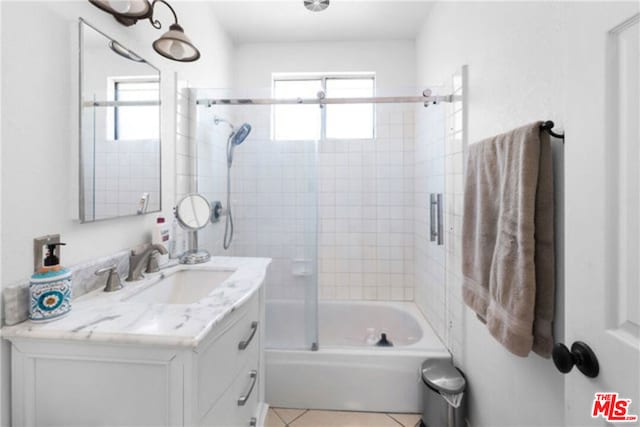 bathroom featuring tile patterned flooring, vanity, and shower / bath combination with glass door