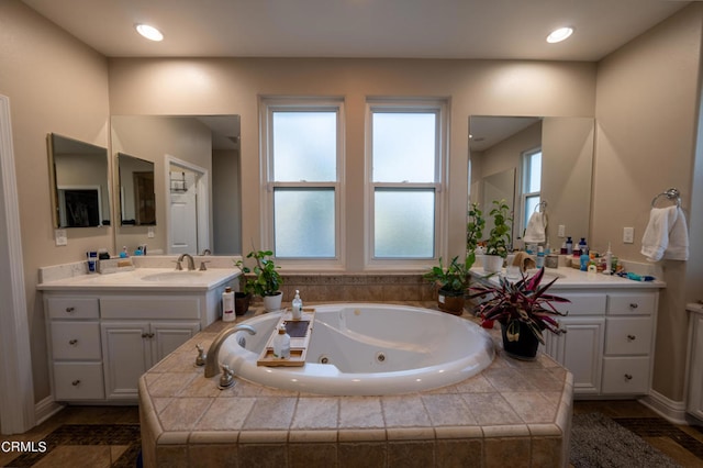 bathroom featuring tiled bath and vanity