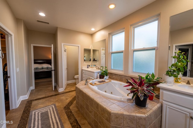 bathroom with vanity, toilet, tile patterned floors, and a relaxing tiled tub