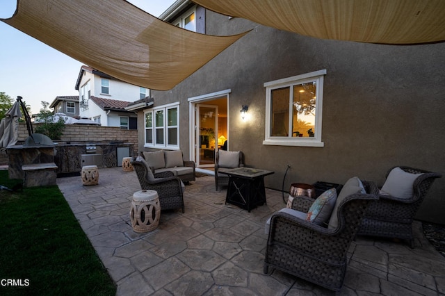 patio terrace at dusk featuring an outdoor living space with a fire pit