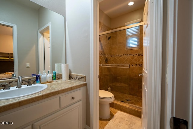 bathroom with walk in shower, vanity, and toilet