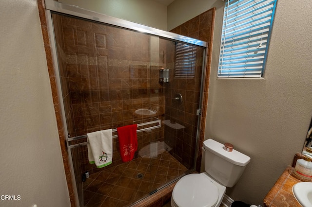 bathroom with vanity, toilet, and a shower with shower door