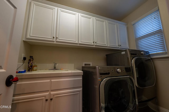 clothes washing area with cabinets, independent washer and dryer, and sink