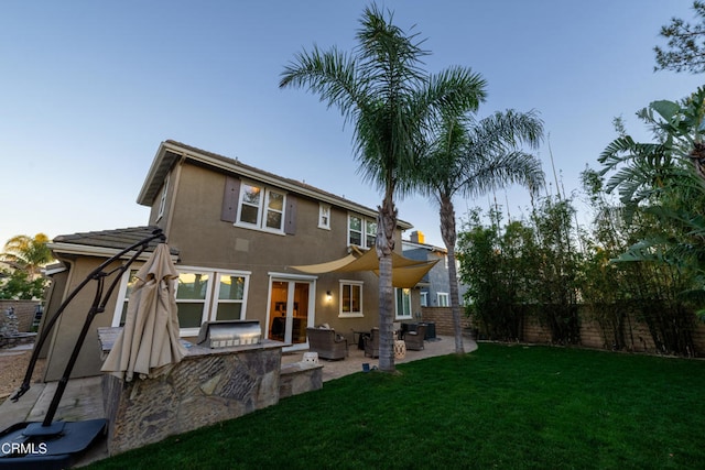 back of property with a lawn and a patio area