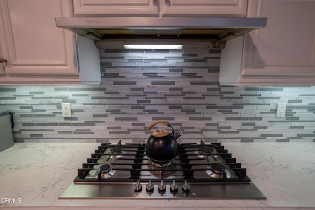 kitchen with gas stovetop, decorative backsplash, and exhaust hood