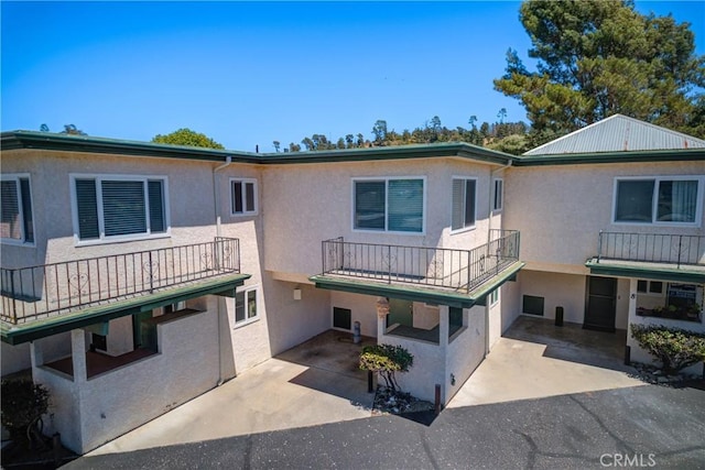 2650 Main St Unit 7, Cambria, CA 93428 - view of front of house with stucco siding, a balcony, driveway, and a patio area