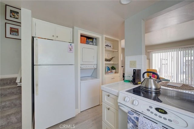 2650 Main St Unit 7, Cambria, CA 93428 - kitchen with white appliances, stacked washing machine and dryer, white cabinetry, and tile countertops
