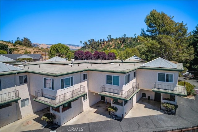 2650 Main St Unit 7, Cambria, CA 93428 - back of property with a garage, stucco siding, a balcony, and a mountain view