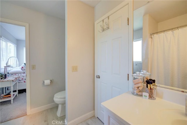 bathroom featuring hardwood / wood-style floors, toilet, and walk in shower