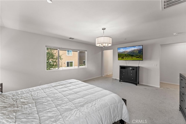 bedroom featuring a notable chandelier and light colored carpet