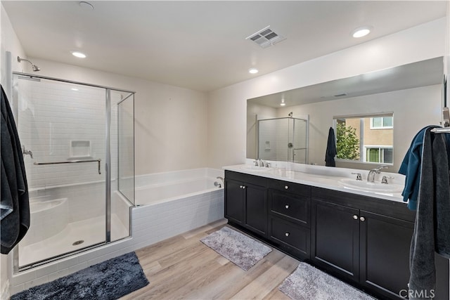 bathroom with vanity, independent shower and bath, and hardwood / wood-style floors