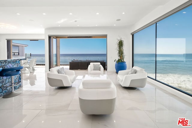 living room featuring a water view and a view of the beach