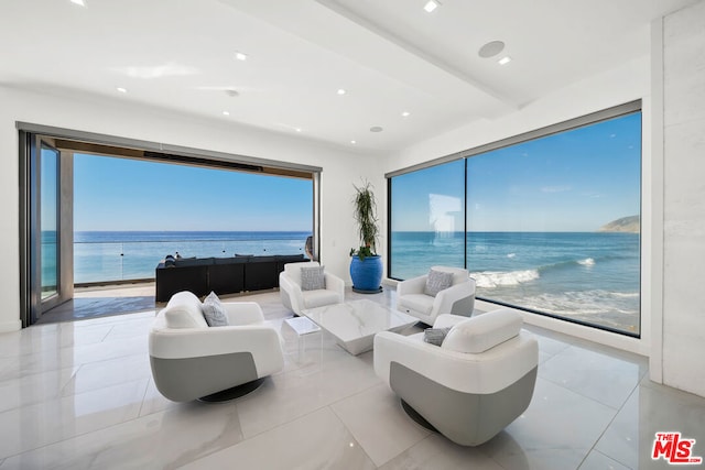 tiled living room featuring a water view