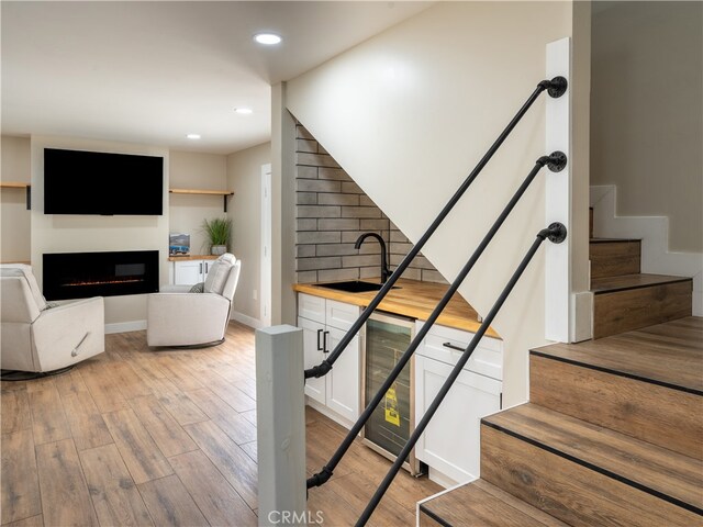 stairs featuring hardwood / wood-style floors and sink