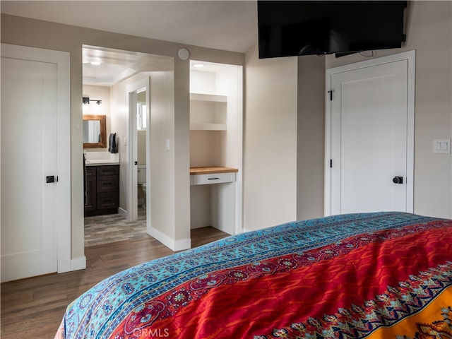 bedroom with hardwood / wood-style flooring and connected bathroom