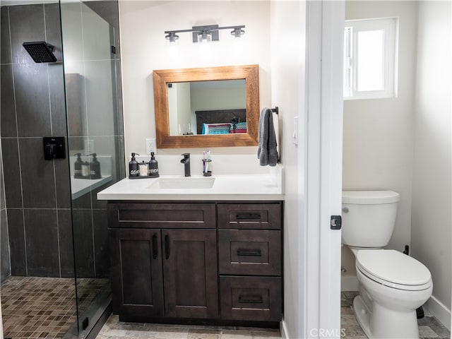 bathroom with vanity, a shower with shower door, and toilet