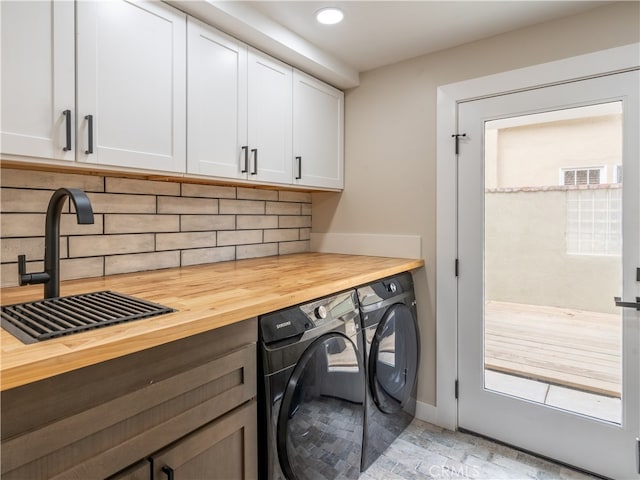 laundry room with cabinets, sink, and separate washer and dryer