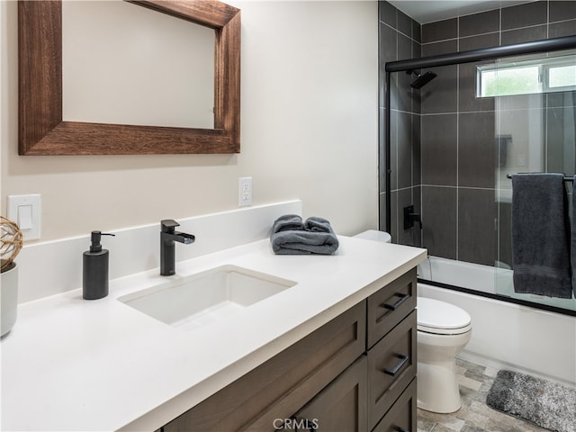 full bathroom featuring vanity, enclosed tub / shower combo, and toilet