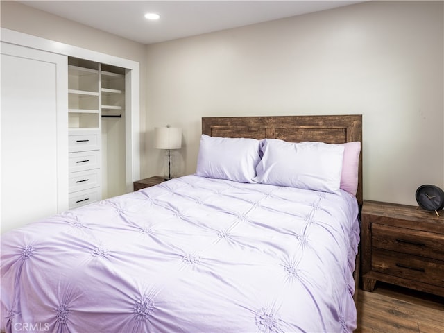 bedroom with a closet and dark hardwood / wood-style flooring