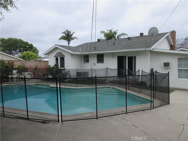 view of swimming pool with central AC unit, a patio, and a wall mounted AC