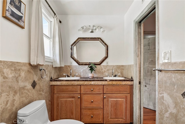 bathroom with tile walls, hardwood / wood-style flooring, a shower with shower door, vanity, and toilet