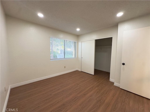 unfurnished bedroom featuring dark hardwood / wood-style flooring and a closet